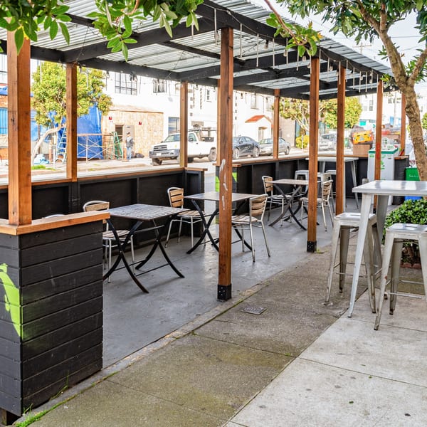 Outdoor patio dining area at Uncle Boy's with tables, chairs, and a covered roof.